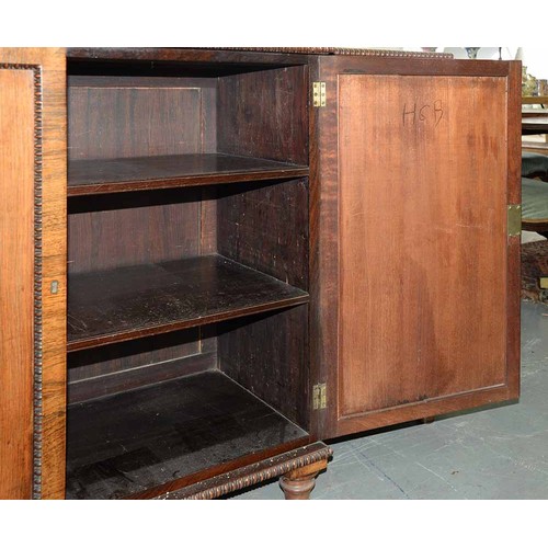 1351 - A George IV rosewood breakfront bookcase, with reel mouldings and fitted with shelves enclosed by pa... 