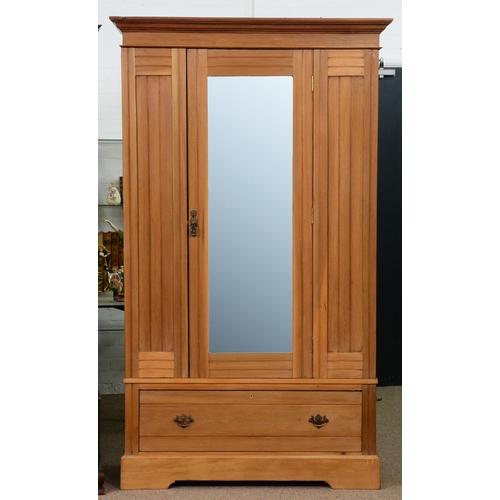 968 - An Edwardian waxed pine wardrobe, with full length bevelled mirror to the door, the base with drawer... 