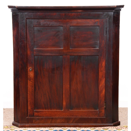 973 - A George III hanging mahogany corner cupboard, fitted with shelves enclosed by four panelled door, 1... 