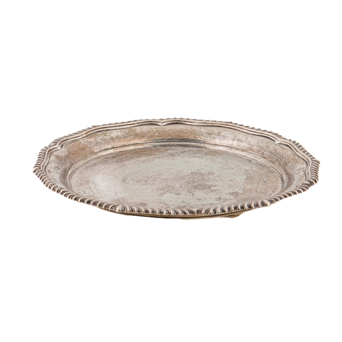 395 - An Edwardian silver salver,  with engraved centre and shaped, gadrooned rim, on three feet, 26cm dia... 