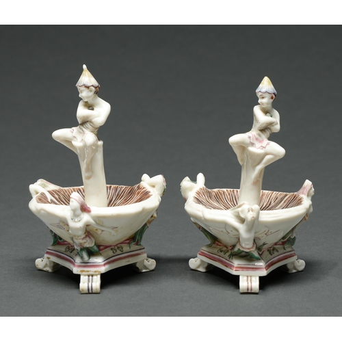 530 - Two early Royal Worcester pixie-on-a-toadstool salt cellars, 1863, supported by three demi figures, ... 