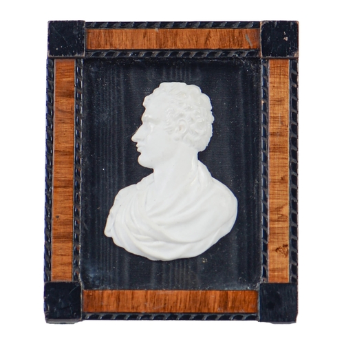 726 - A glass paste bas relief portrait of Lord Byron, 73mm, laid down on black moire silk, in ebonised an... 