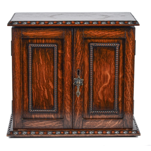 783 - An oak smoker's cabinet, early 20th c, the fitted interior enclosed by panelled doors, 28.5cm h; 20 ... 