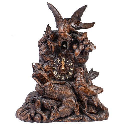 899 - A Swiss limewood cuckoo clock, late 19th c, in the form of a rocky crag surmounted by an eagle swoop... 