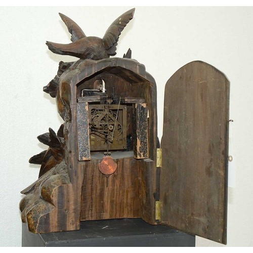 899 - A Swiss limewood cuckoo clock, late 19th c, in the form of a rocky crag surmounted by an eagle swoop... 