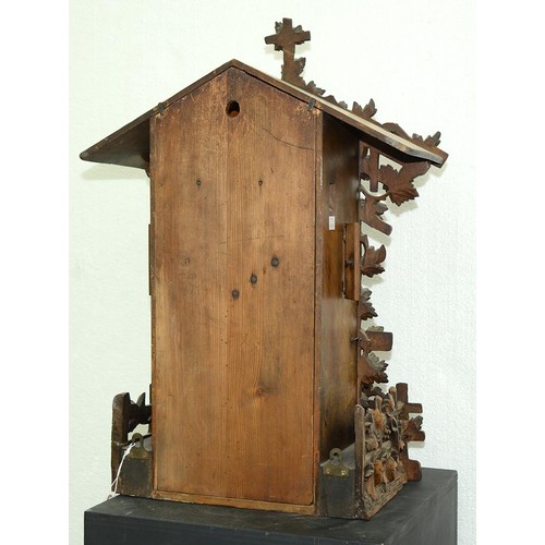 900 - A Swiss walnut cuckoo clock, late 19th c, in the form of a chalet embowered with fruiting vines cent... 