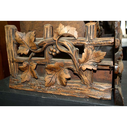 900 - A Swiss walnut cuckoo clock, late 19th c, in the form of a chalet embowered with fruiting vines cent... 