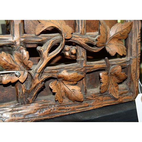 900 - A Swiss walnut cuckoo clock, late 19th c, in the form of a chalet embowered with fruiting vines cent... 