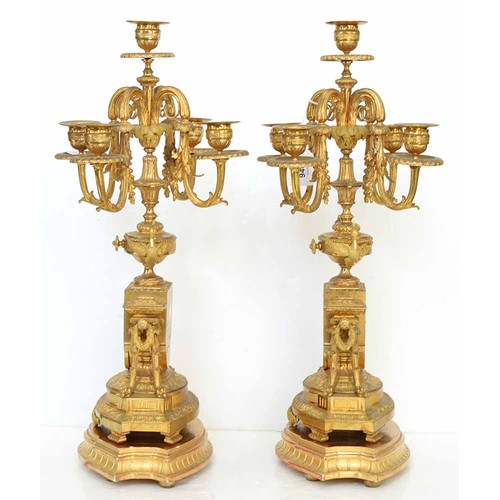 948 - An ormolu garniture de cheminee, 19th c, the ornate case with urn finial with bird handles and pinea... 