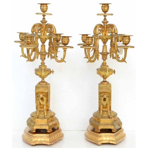 948 - An ormolu garniture de cheminee, 19th c, the ornate case with urn finial with bird handles and pinea... 