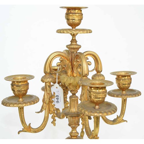 948 - An ormolu garniture de cheminee, 19th c, the ornate case with urn finial with bird handles and pinea... 