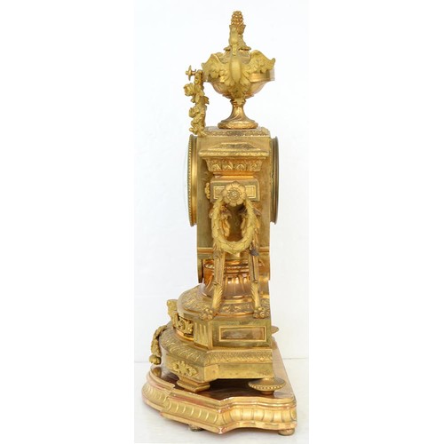 948 - An ormolu garniture de cheminee, 19th c, the ornate case with urn finial with bird handles and pinea... 