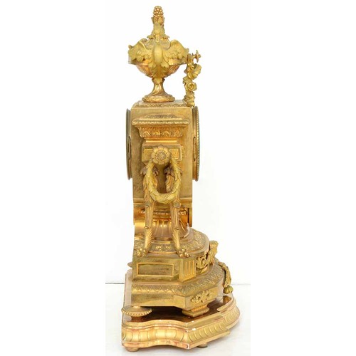 948 - An ormolu garniture de cheminee, 19th c, the ornate case with urn finial with bird handles and pinea... 