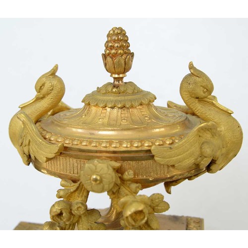 948 - An ormolu garniture de cheminee, 19th c, the ornate case with urn finial with bird handles and pinea... 