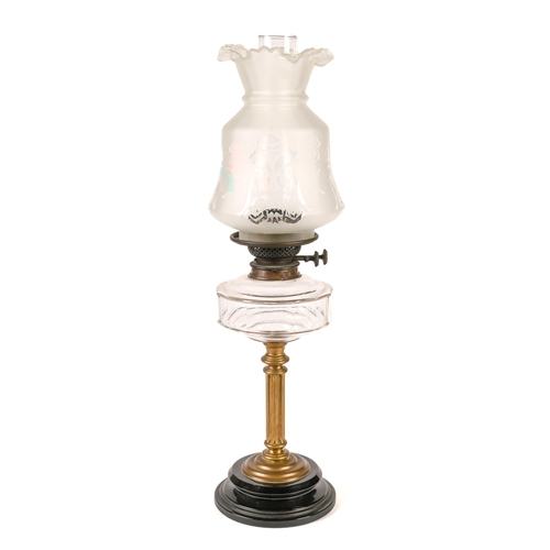 100 - An Edwardian brass columnar oil lamp,  with faceted glass fount and brass burner, on black glaed ear... 