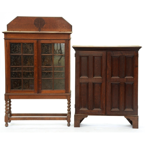 543 - An oak bookcase, early 20th c, with four panel doors, on bracket feet, 110cm h; 26 x 90cm and an oak... 