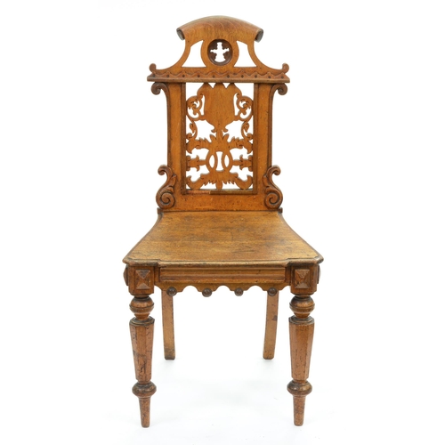 658 - A Victorian Elizabethan Revival oak hall chair, with pierced back, shaped apron to the seat rail and... 