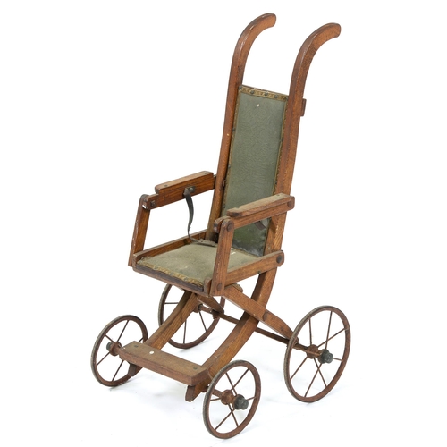 668 - An Edwardian oak folding doll's pushchair, on iron wheels with solid rubber tyres, 78cm h... 