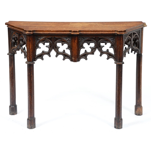 670 - A Victorian gothic oak side table, with carved pierced apron on octagonal columnar legs and moulded ... 