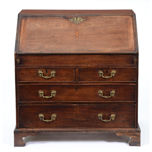 673 - A George III mahogany bureau, with stepped and fitted interior and well, the flap with oval pattera,... 