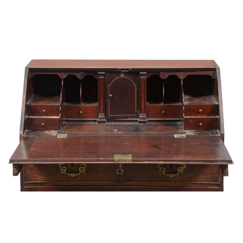 673 - A George III mahogany bureau, with stepped and fitted interior and well, the flap with oval pattera,... 