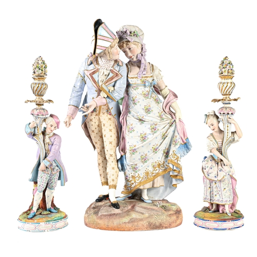 95 - A French biscuit group of lovers  arm in arm, on a rocky base and painted in pastel hues, with raise... 