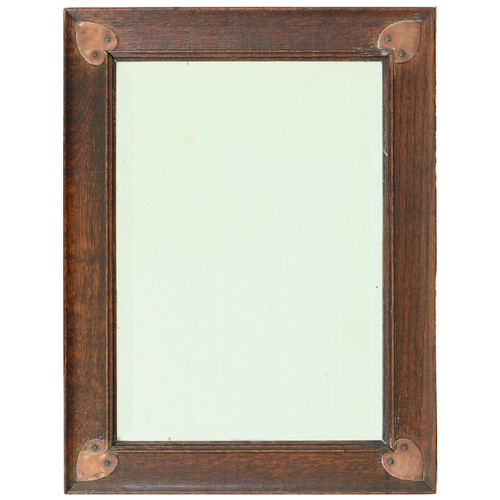 690 - An Arts & Crafts oak mirror, c1910, the bevelled plate in cavetto frame applied with heart shape... 