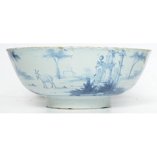 17 - An English delftware punch bowl, London, c1750-60, painted to the exterior with a continuous  landsc... 