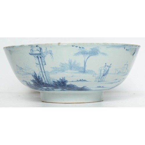 17 - An English delftware punch bowl, London, c1750-60, painted to the exterior with a continuous  landsc... 