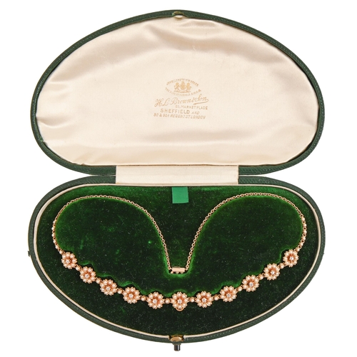 100 - A diamond and split pearl necklet, early 20th c, the eleven flower clusters divided by single split ... 