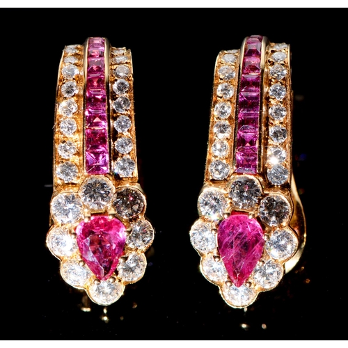 101 - A pair of ruby and diamond ear clips, with heart shaped cluster and line and calibre cut rubies, in ... 