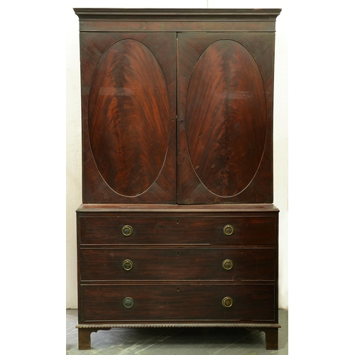 1024 - A George III mahogany linen press, with figured oval door panels enclosing trays, the projecting che... 