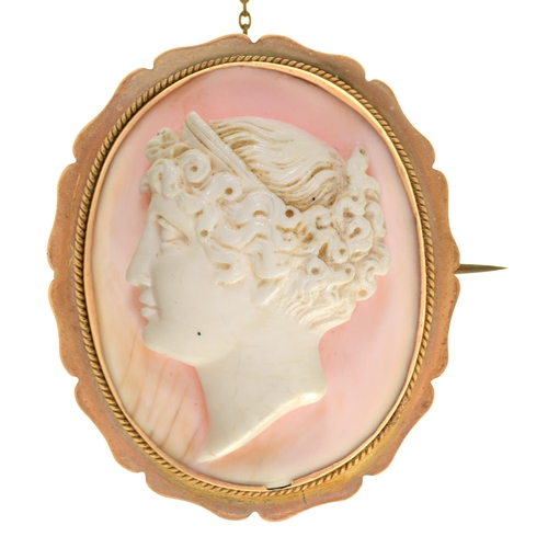 21 - A cameo brooch, the oval white coral carved with the head of a bacchante, 40mm, marked 9ct... 