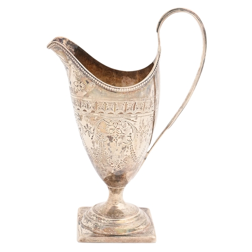 313 - A George III bright cut and engraved silver cream jug, of helmet shape with reeded handle and beaded... 