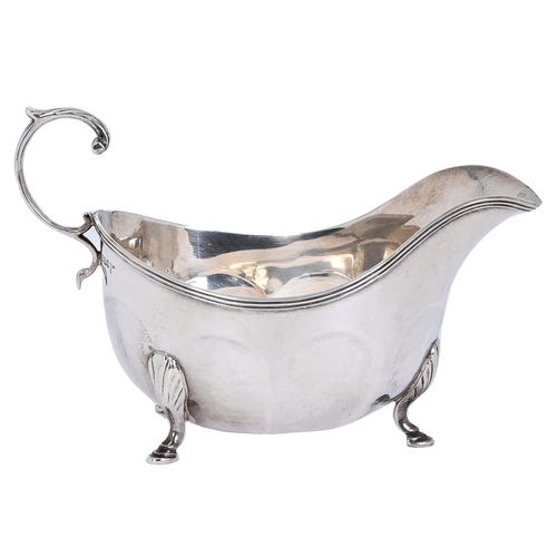 318 - A George V silver sauceboat, with reeded rim and flying scroll handle, 17cm l, by Walker & Hall,... 