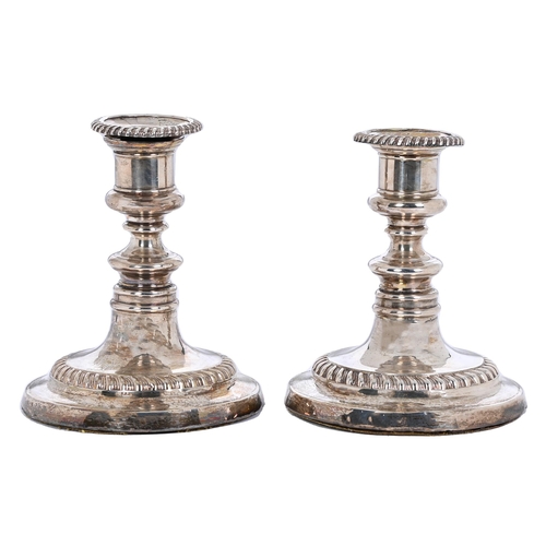 322 - A pair of George III dwarf gadrooned silver candlesticks, crested, nozzles, 14cm h, by John and Thom... 