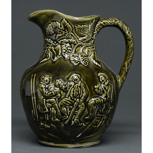 556 - A Staffordshire olive green glazed moulded earthenware jug, late 19th c, with tavern scene, 22.5cm h... 