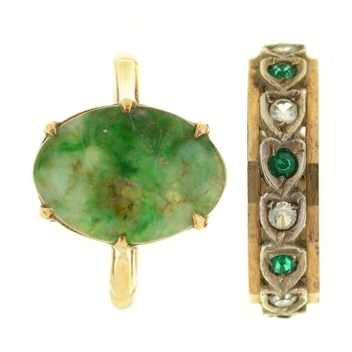 64 - A carved jade ring, in gold marked 9ct and a green and white paste eternity ring in gold marked 9ct,... 