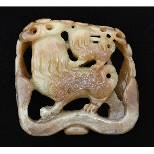 642 - A Chinese jade pebble carving of dogs of Fo within flowers, 88mm h