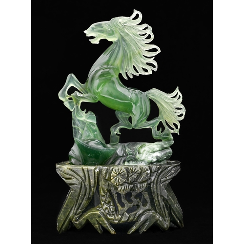 666 - A Chinese jade carving of a prancing horse, 18cm h, carved stone stand