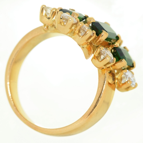 79 - A diamond ring, with three step cut green tourmalines, in gold marked 18, 8.5g, size L... 