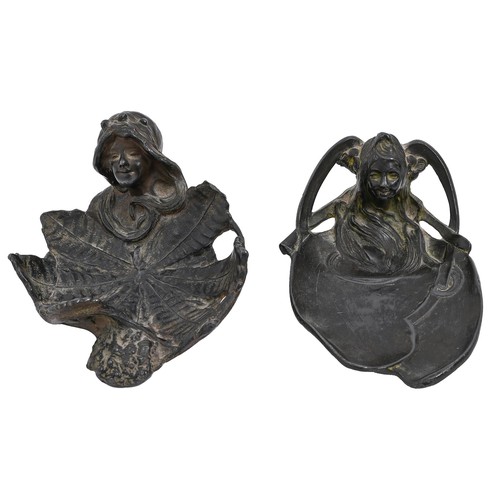 669 - Two art nouveau pewter pin trays in the form of the head of a young woman issuing from a lily or lea... 