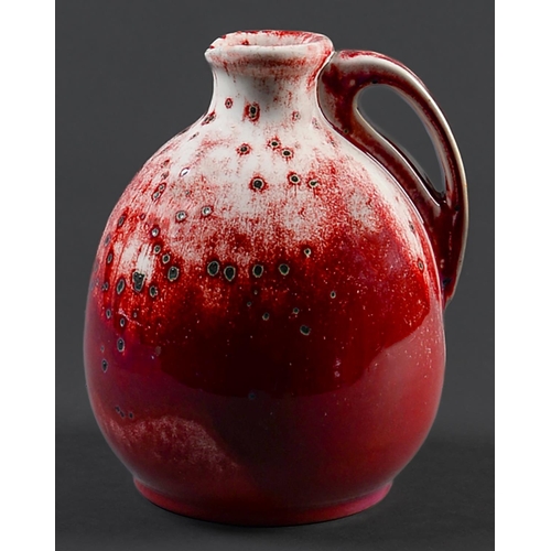 65 - A Ruskin flambé ewer, 1933,  of onion form, the rich crimson red glaze over an ivory ground and suff... 