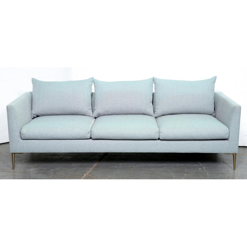 A three seat contemporary sofa, upholstered in pale blue fabric, on
