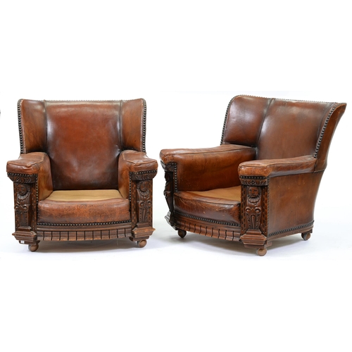 1274 - A pair of carved oak and close nailed brown hide easy armchairs, c1930, with Tudor style terms, seat... 