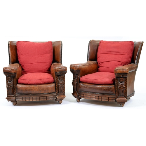 1274 - A pair of carved oak and close nailed brown hide easy armchairs, c1930, with Tudor style terms, seat... 