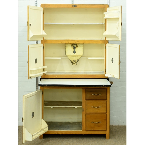 1360 - An early 20th c Hygena kitchen cupboard, with sliding enamelled work surface, the fitted interior wi... 