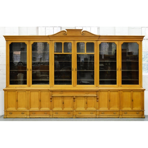 1365 - An unusually large Victorian scumbled breakfront bookcase, the central pediment with tablet and volu... 