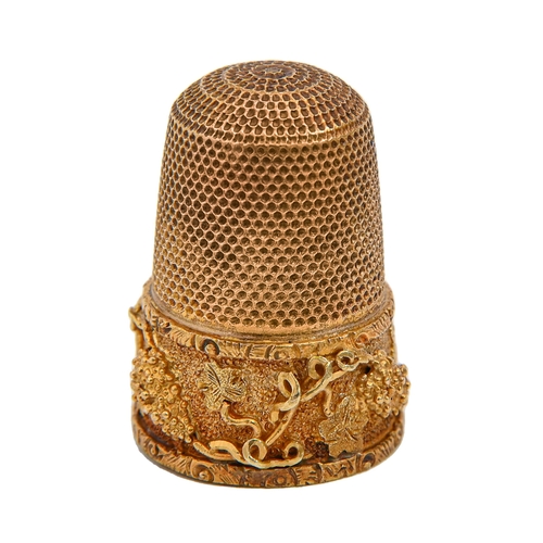 403 - A gold thimble, c1900, with skirt of finely applied and chased grapevines, 24mm h, inscribed 15ct, c... 