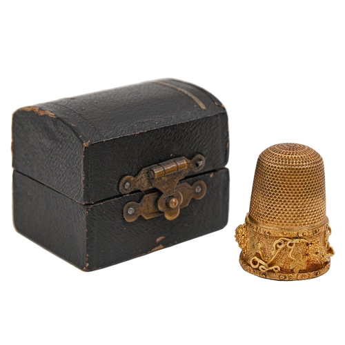 403 - A gold thimble, c1900, with skirt of finely applied and chased grapevines, 24mm h, inscribed 15ct, c... 